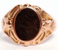 Early 20th century 9ct gold signet ring, the plain oval panel raised between carved shoulders,