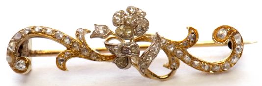 Antique precious metal diamond brooch, a design featuring a central diamond set flower head within a