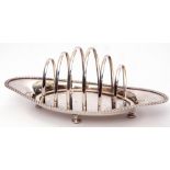 Late Victorian toast rack of six graduated hooped bars to a boat shaped base with gadrooned rim