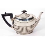 George V bachelor's tea pot of half fluted oval form with angular ebonised handle, Sheffield 1910 by