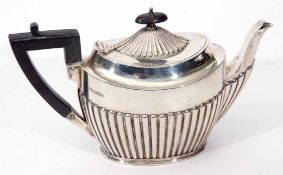 George V bachelor's tea pot of half fluted oval form with angular ebonised handle, Sheffield 1910 by