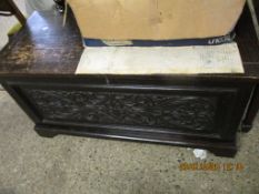 EARLY 20TH CENTURY OAK FRAMED COFFER WITH HEAVILY CARVED FRONT PANEL RAISED ON BRACKET FEET