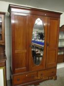 EDWARDIAN MAHOGANY DOUBLE DOOR WARDROBE WITH INSET OVAL MIRROR, THE BASE WITH TWO DRAWERS WITH