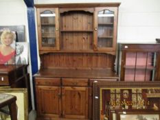 STAINED PINE DRESSER FITTED CENTRALLY WITH TWO SHELVES FLANKED EITHER SIDE WITH GLASS DOORS, THE