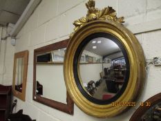 19TH CENTURY GILT FRAMED CONVEX WALL MIRROR WITH EBONISED SLIP AND CARVED TOP