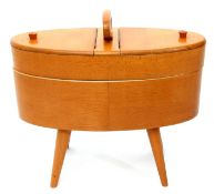 Circa 1950s plywood sewing box with central carry handle and revolving movement supported on splayed