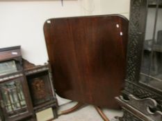 GEORGIAN MAHOGANY SQUARE TILT TOP TABLE WITH A SPLAYED TRIPOD BASE AND BRASS CAPPED CASTERS