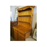 STAINED PINE DRESSER WITH TWO FIXED SHELVES, THE BASE WITH TWO DRAWERS OVER TWO CUPBOARD DOORS