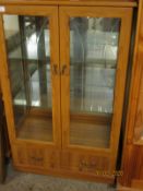 PINE EFFECT TWO GLAZED DOOR DISPLAY CABINETS WITH FULL WIDTH DRAWER TO BASE