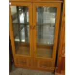 PINE EFFECT TWO GLAZED DOOR DISPLAY CABINETS WITH FULL WIDTH DRAWER TO BASE