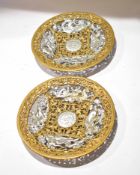 Pair of circular pierced gilded and silvered cast metal plaques depicting mythological figures, 22cm