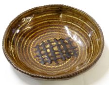 Art Pottery slip ware dish with a portcullis design to centre in tones of brown slip, JS monogram to
