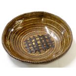 Art Pottery slip ware dish with a portcullis design to centre in tones of brown slip, JS monogram to