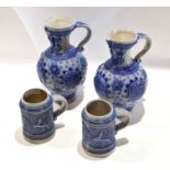 Group of two German salt glaze pottery jugs with blue designs in relief, together with two tankards,