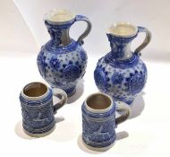 Group of two German salt glaze pottery jugs with blue designs in relief, together with two tankards,