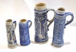 Group of four German stoneware steins or tankards with typical designs, largest with scroll