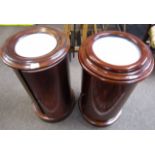 Matched pair of Victorian style mahogany cylindrical pot cupboards with single doors, marble