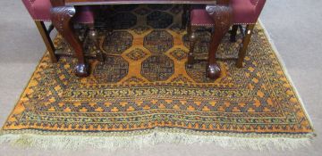 Small Afghan wool carpet with black geometric and medallion designs to an orange ground, 278cm x