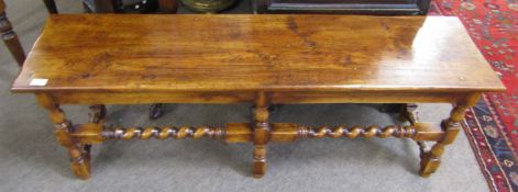 Early 20th century oak stool of rectangular form with planked top over twisted stretchers, 130cm