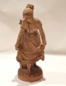 Continental terracotta figure of a dancing girl on oval base, 48cm high