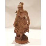 Continental terracotta figure of a dancing girl on oval base, 48cm high