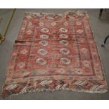 Caucasian wool carpet, central panel of geometric lozenges, mainly red/puce field, (faded and worn),