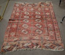 Caucasian wool carpet, central panel of geometric lozenges, mainly red/puce field, (faded and worn),