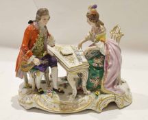 Continental porcelain group of a lady and gentleman, the lady playing the piano, on a scroll gilt