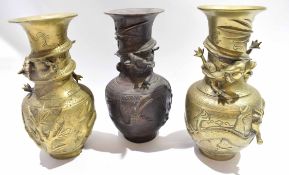 Group of three Oriental metal vases, all decorated in relief with dragons to the neck with further