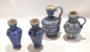 Group of four German salt glaze pottery jugs all with typical designs in blue and manganese (4)