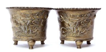 Two Oriental brass jardinieres decorated with dragons, on three stub feet with reign mark to base,
