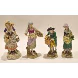 Four Continental porcelain figurines of street sellers on typical gilt scroll bases