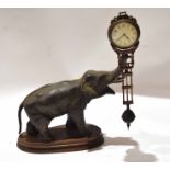 Bronzed metal mystery clock, modelled as an elephant with a clock balanced to its trunk, 31cm long