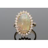 Opal and diamond dress ring, the oval shaped cabochon opal raised within a small diamond surround,