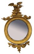 Regency period gilt framed circular convex wall mirror crested with a dragon and fish and applied