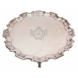 George V plain small silver waiter of circular form with "Chippendale" edge and supported on four