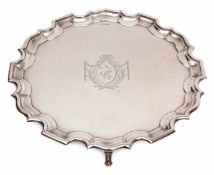 George V plain small silver waiter of circular form with "Chippendale" edge and supported on four