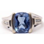 Precious metal sapphire and diamond ring, the centre barrel shaped sapphire raised between diamond