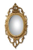 19th century gilt and gesso oval mirror with a scrolling open work surround and mounted with a