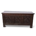 18th century large proportion oak coffer with a carved three panel front with floral and scrolling