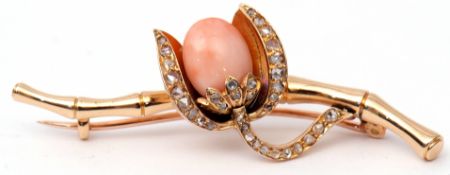 Antique coral and diamond brooch centring a coral bud in a diamond set cup within a diamond