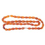 Vintage amber necklace, a single row of graduated olive shaped beads, cognac or honey colour, with