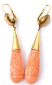 Pair of vintage carved coral torpedo drop earrings, each carved one side with a figure, the other