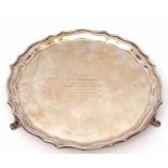 George V salver of shaped circular form with wavy edge, supported on three curved feet, presentation