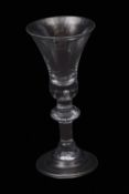 An important early 18th century heavy baluster wine glass with bell bowl with tiered solid base