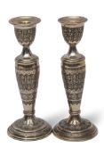 Pair of Persian white metal candlesticks, modelled with warriors in relief, 20cm high