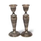 Pair of Persian white metal candlesticks, modelled with warriors in relief, 20cm high