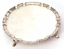 George V plain small silver waiter of circular form with "Chippendale" edge and supported on four