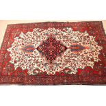 Early 20th century Oriental silk/wool carpet, triple gull border and central floral lozenge,