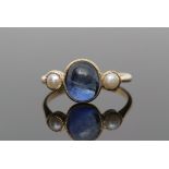 Sapphire and pearl ring, centring an oval cabochon sapphire between two small seed pearls, each